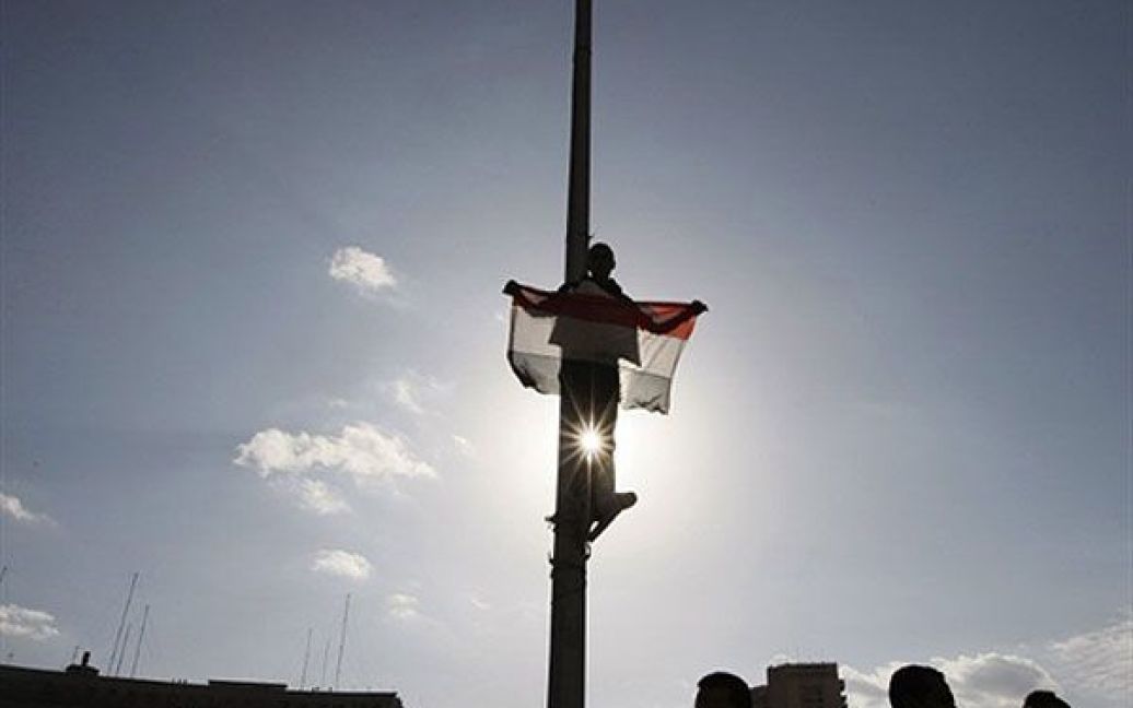 Єгипет, Каїр. Єгипетський демонстрант тримає національний прапор під час акції протесту на площі Тахрір у Каїрі. Єгипет закликав президента Хосні Мубарака піти у відставку. / © AFP