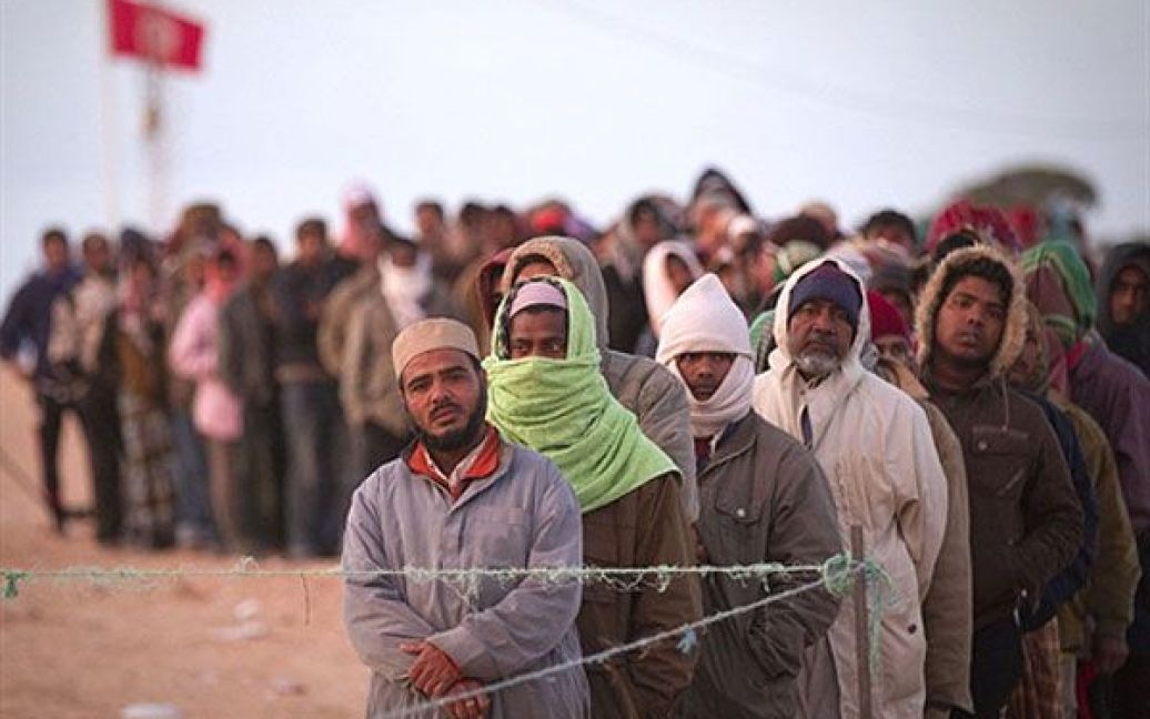 Туніс. Біженці, які втекли з Лівії, стоять у черзі на отримання їжі в таборі біженців поблизу туніського кордону. / © AFP