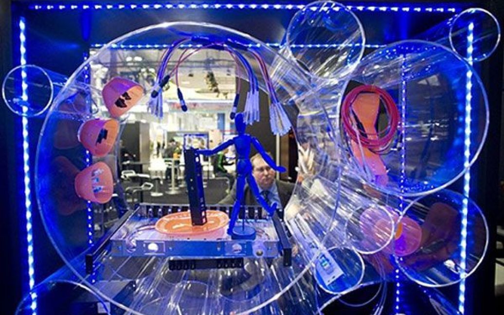 Німеччина, Ганновер. Відвідувач роздивляється стенд на виставці CeBIT у Ганновері, в якій цього року беруть участь понад 4200 високотехнологічних компаній з 70 країн світу. / © AFP