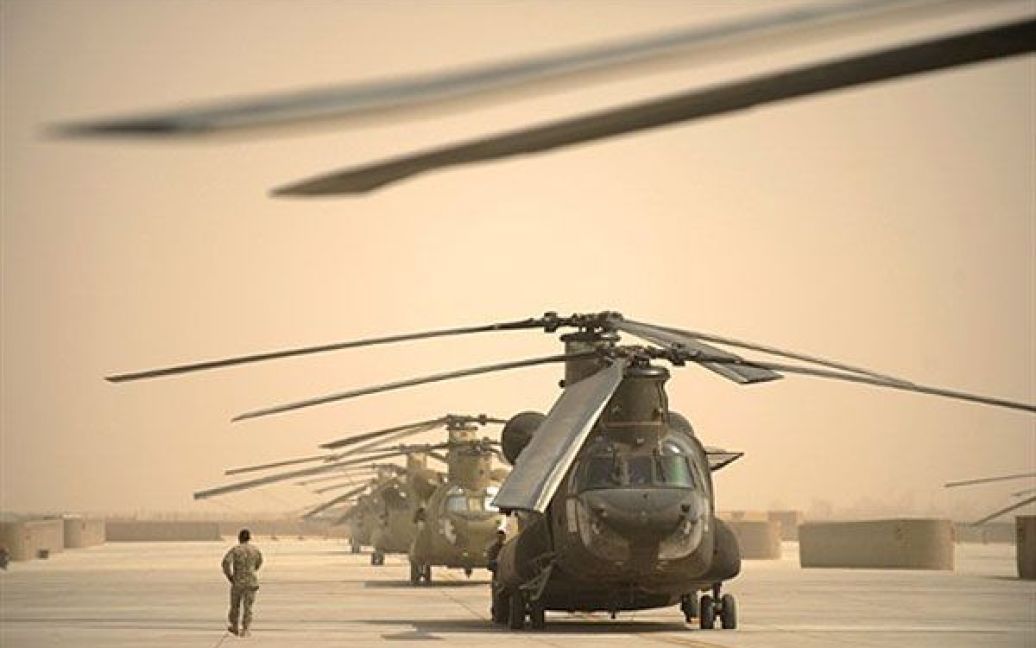 Афганістан, Кандагар. Американський льотчик проходить повз гелікоптери "Чінук" на авіабазі Кандагар. Коаліційні сили змогли зупинити талібів у деяких районах Афганістану. / © AFP