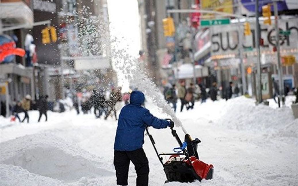 США, Нью-Йорк. Чоловік розчищає сніг на Таймс-сквер в Нью-Йорку після
сильної хуртовини. Потужна заметіль на північному сході США призвела
до закриття аеропортів і проблем з автомобільним і залізничним рухом. / © AFP