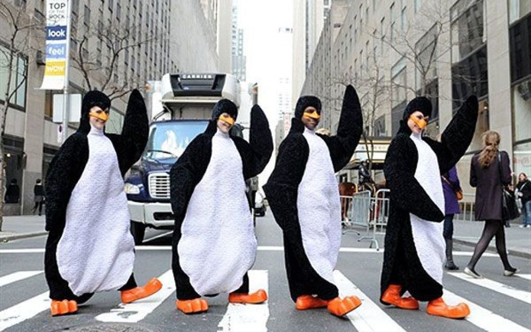 США, Нью-Йорк. Актори у костюмах пінгвінів з мюзиклу "Madagascar Live" переходять вулицю поруч із Рокфеллер-центром в Нью-Йорку. / © AFP