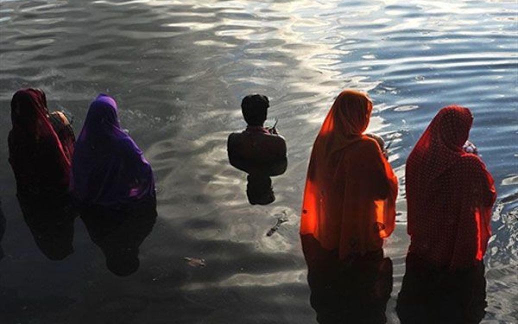 Індія, Бангалор. Індуїсти моляться Сонцю під час релігійного свята Chhath, стоячи у воді в Бангалорі. Свято Chhat присвячене Господу Сурья (Сонцю), Агні (вогню) і богу Картікея (Мурга). Люди моляться за благополуччя сім&#039;ї, оскільки вважається, що бажання людей виповняться, якщо вони дотримуватимуться Пуджі. / © AFP