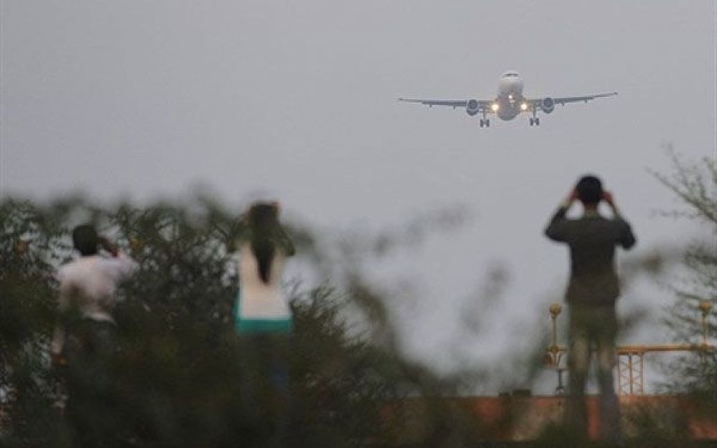 Індія, Ахмедабад. Люди дивляться, як літак наближається до аеропорту в
Ахмедабаді. Тисячі пасажирів застрягли в аеропоту, оскільки багато
рейсів по всій Індії було відстрочено або скасовано через погану
видимість і густий туман. / © AFP