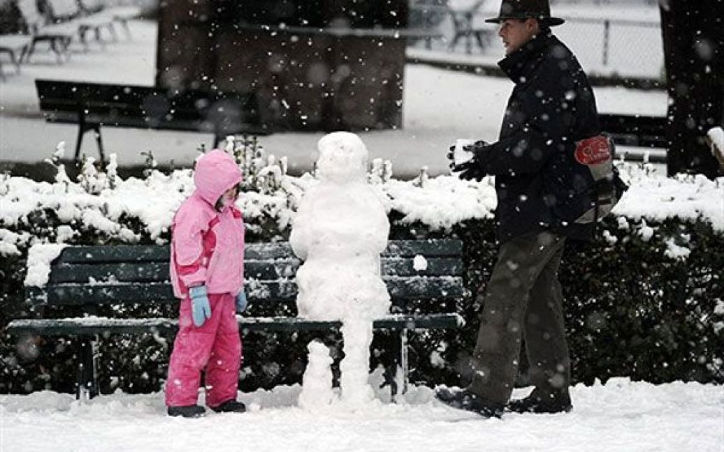 Франція, Париж. Люди ліплять сніговика у парку в Парижі. Через сильні снігопади був закритий паризький аеропорт Шарля де Голля і припинено відвідування Ейфелевої вежі. / © AFP