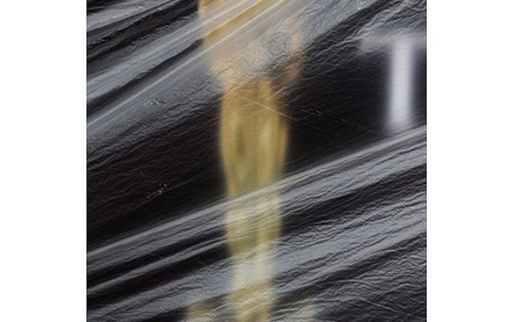США, Голлівуд. Скульптура "Оскара", вкрита пластиковим тентом, встановлена на червоній килимовій доріжці перед театром "Кодак" на бульварі Голлівуд, штат Каліфорнія. 27 лютого у театрі "Кодак" відбудеться 83-тя щорічна церемонія вручення премії "Оскар". / © AFP