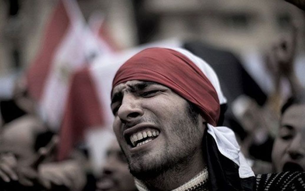Єгипет, Каїр. Єгипетський антиурядовий демонстрант бере участь приймає у поминальній ході після похорону журналіста Ахмеда Мухаммеда Махмуда, убитого під час зіткнень прихильників уряду і антиурядових демонстрантів на площі Тахрір у центрі Каїра. / © AFP