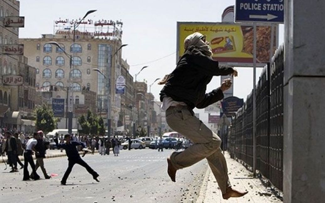 Ємен, Сана. Антиурядовий єменський демонстрант кидає каміння у напрямку поліцейської ділянки під час зіткнень з прихильниками режиму у центрі столиці Ємену Сани. / © AFP