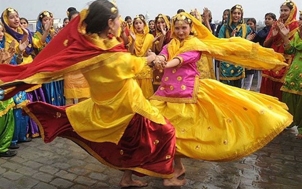 Індія, Амрітсар. Дівчатка зі школи танцю, одягнені у традиційний народний одяг "гідда", танцюють на святкуванні Басант Панчамі, фестивалю весни у Амрітсарі. Найяскравішою подією фестивалю є запуск кольорових повітряних зміїв. / © AFP