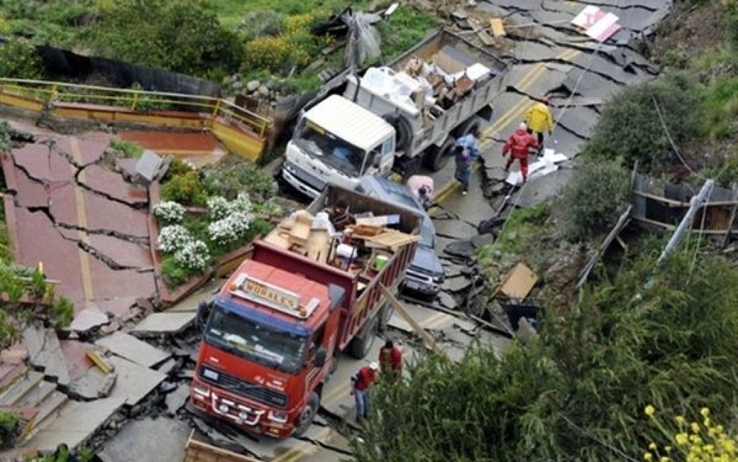 Болівія, Ла-Пас. Місцеві жителі намагаються врятувати свої речі з вантажівок, які застрягли у проваллі поблизу міста Ла-Пас. В результаті зсувів та обвалів, викликаних проливними дощами, щонайменше 150 будинків були зруйновані. / © AFP