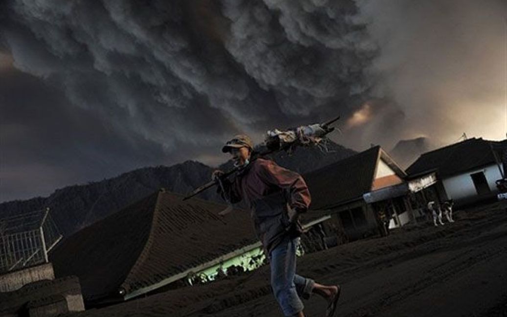 Індонезія, Чеморо Лаванг. Індонезієць йде вулицею селища Чеморо Лаванг, засипаною попелом. В Індонезії почав вивергатись вулкан Бромо. / © AFP