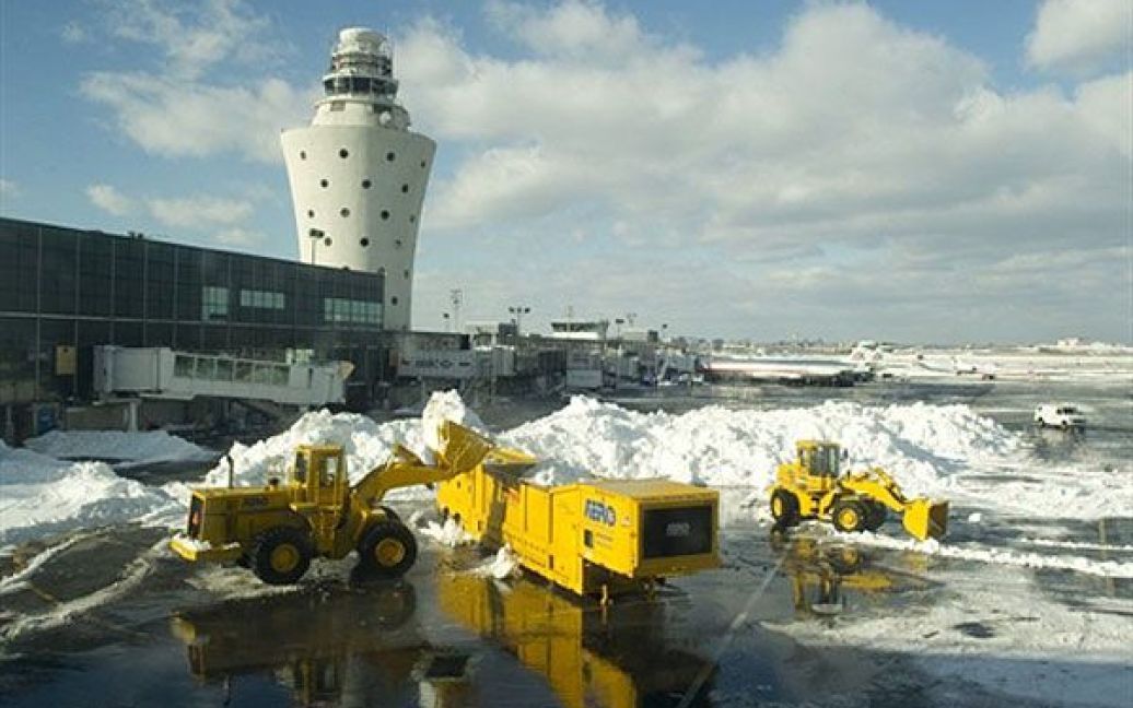 США, Нью-Йорк. Працівники прибирають сніг зі злітної смуги в аеропорту LaGuardia у Нью-Йорку. На північному сході США почали позбавлятися наслідків однієї з найбільших заметілей цього року / © AFP