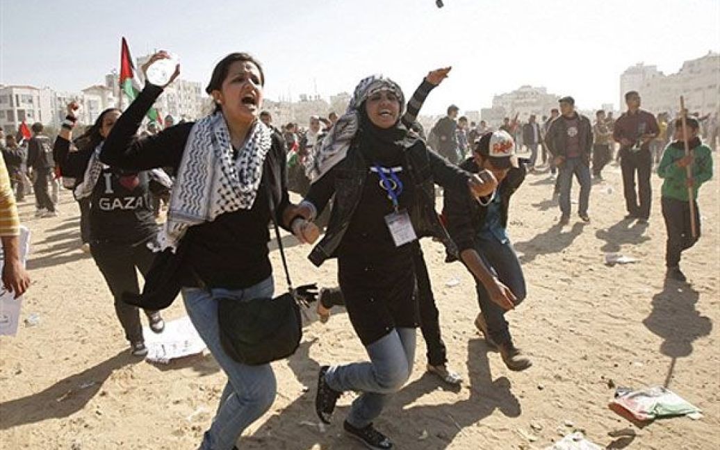 Місто Газа. Палестинські демонстранти тікають від зіткнень, що стались між прибічниками руху ХАМАС і прихильниками інших організацій під час мітингу. На мітингу лунали заклики до палестинської політичної єдності. / © AFP