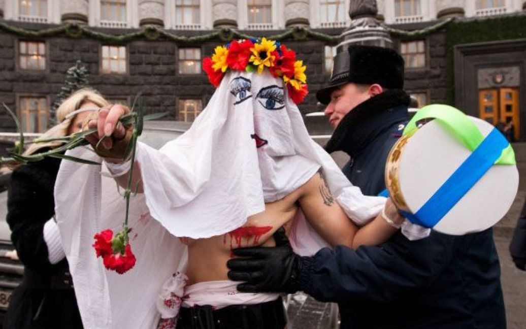 Активістка руху FEMEN в образі "кровосісі" спробувала прорватися до будівлі Кабінету міністрів і особисто вручити Миколі Азарову квіти і торт. / © Украинское Фото