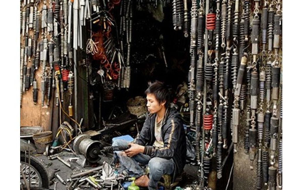 В&#039;єтнам, Ханой. Механік працює у придорожньому магазині і майстерні з ремонту мотоциклів у центрі Ханою. / © AFP