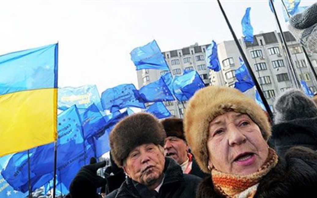 Мітингуючі тримають прапори Європейської партії України та ВО "Батьківщина". / © AFP