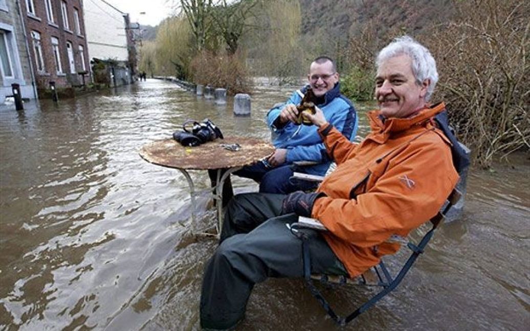 Чоловіки п&rsquo;ють пиво на затопленій вулиці міста Еньо (Бельгія), поблизу річки Урт / © AFP