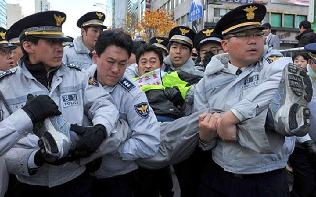 Республіка Корея, Сеул. Південнокорейська поліція затримує члена профспілки під час акції протесту біля готелю Ritz-Сarton у Сеулі, де 11 листопада розпочався дводенний саміт лідерів G20. / © AFP