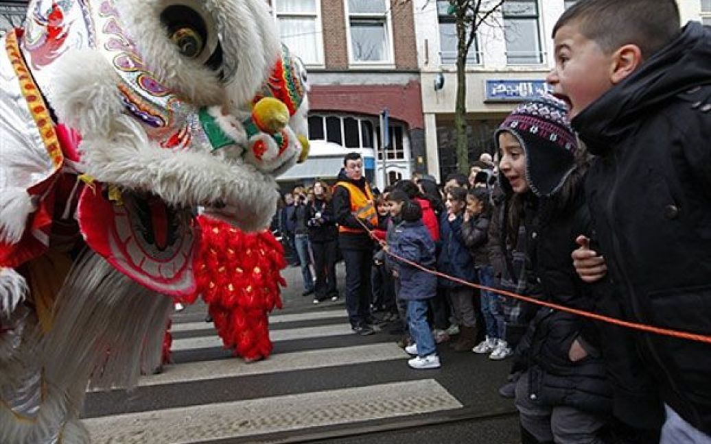 Нідерланди, Роттердам. Діти дивляться на лялькового тигра під час святкування Нового року за китайським календарем у Роттердамі. / © AFP