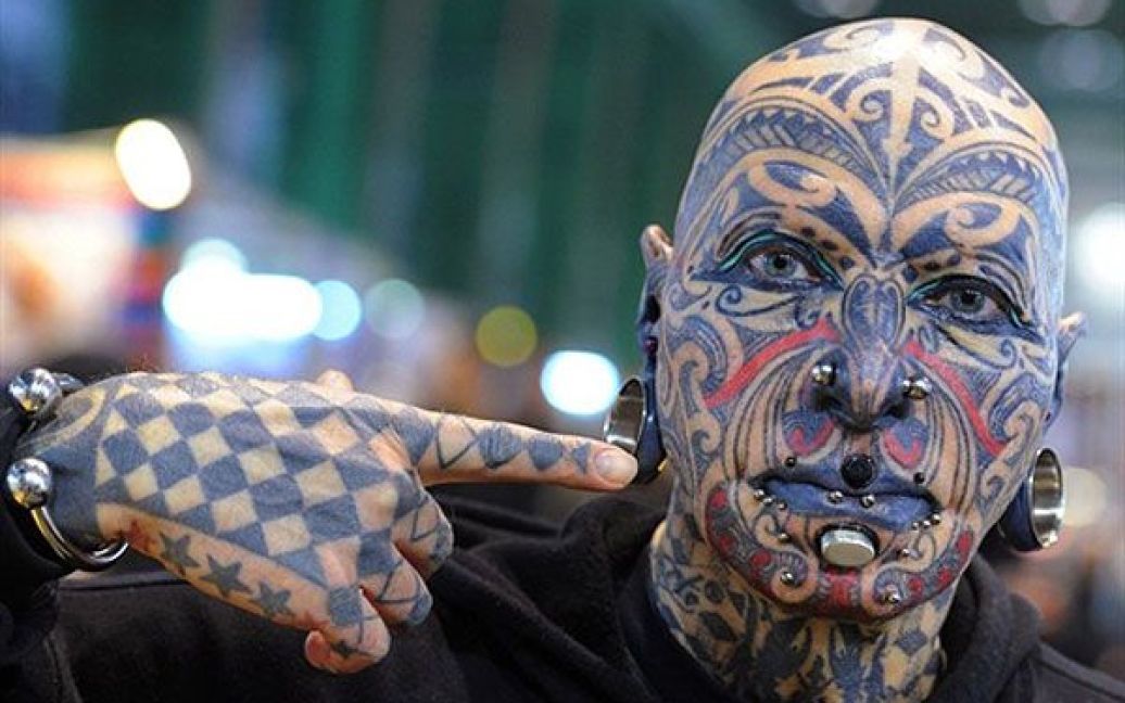 Німеччина, Берлін. Чоловік позує для фотографів, показуючи свої татуювання, під час 20-ої Міжнародної тату-конвенції, яка відбулась у будівлі аеропорту Темпельхоф у Берліні. / © AFP