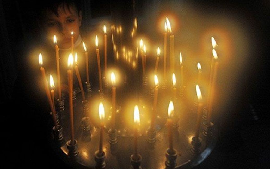 Киргизстан, Бішкек. Хлопчик запалює свічку під час служби у церкві міста Бішкек. Православні християни святкують Різдво за старим юліанським календарем. / © AFP