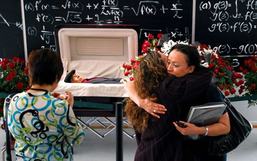 Студентки обнімаються поруч із труною з тілом колишнього вчителя математики Джемі Ескаланте, яка стоїть у колишній класній кімнаті школи Гарфілд в Лос-Анджелесі. (Wally Skalij/Los Angeles Times) / © Los Angeles Times