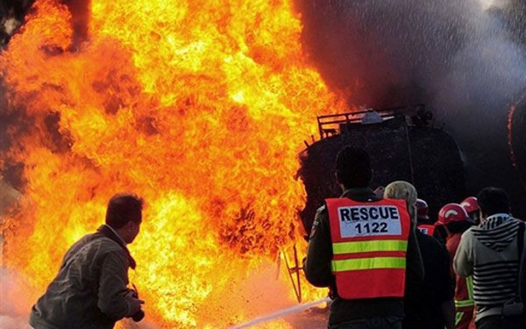 Пакистан, Пешавар. Пакистанські пожежні намагаються загасити палаючий нафтовий танкер НАТО після вибуху в Пешаварі. В результаті вибухів загинули троє співробітників служб безпеки, було знищено цистерни з нафтою. / © AFP