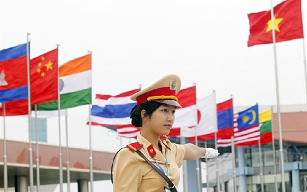 В&#039;єтнам, Ханой. В&#039;єтнамська жінка-поліцейський регулює рух в аеропорту Ной Бай у Ханої. Азіатські лідери почали прибувати на саміт АСЕАН, який повинен початися у Ханої 28 жовтня. / © AFP