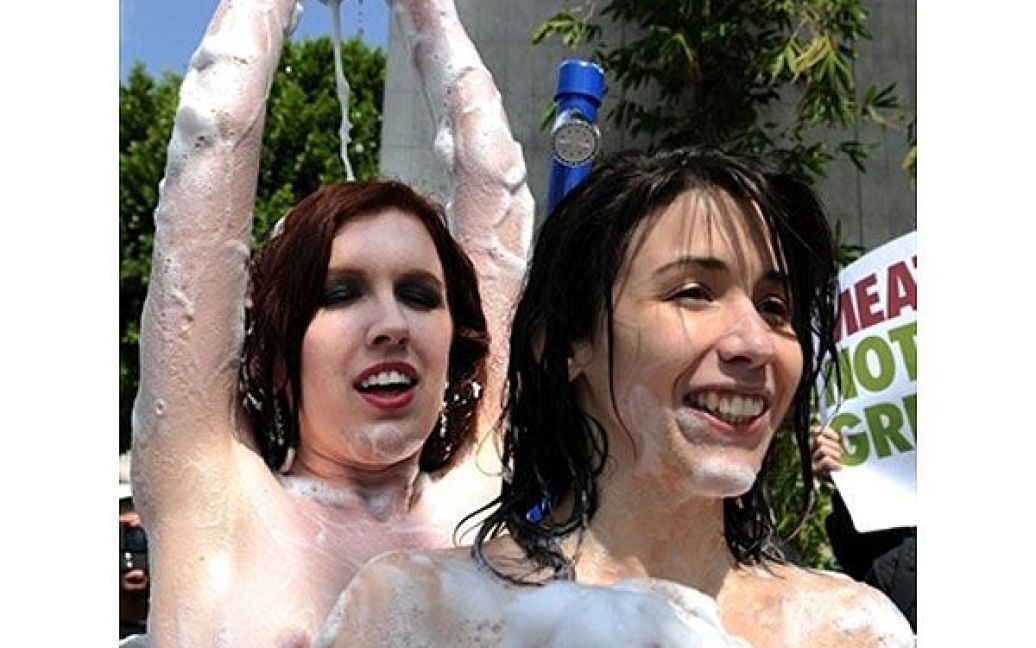 США, Голлівуд. Дві оголені дівчини з організації PETA приймають душ на вулиці Голлівуду під час святкування Всесвітнього дня водних ресурсів. / © AFP