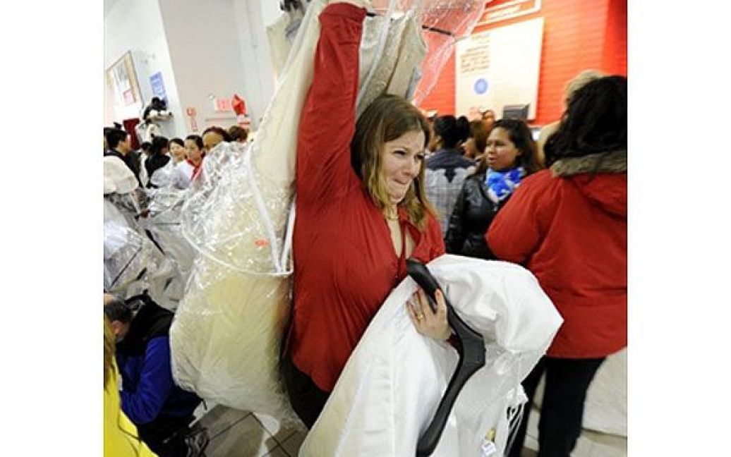 США, Нью-Йорк. Жінка несе весільні сукні під час підготовки до щорічної події "Забіг наречених", на якій проходить розпродаж дизайнерських весільних суконь. / © AFP