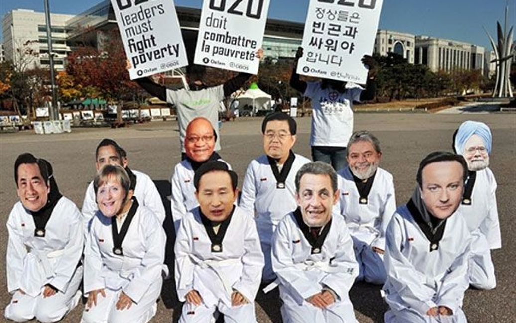 Республіка Корея, Сеул. Активісти руху "Oxfam" у масках із зображеннями облич лідерів країн G20 провели акцію протесту у сеульському парку напередодні саміту G20. 11 листопада світові лідери почнуть дводенні переговори на вищому рівні щодо відновлення рівноваги у світовій економіці. / © AFP