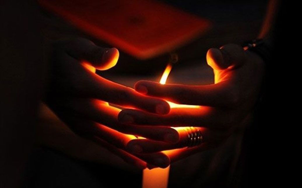 Індія, Бангалор. Тибетський буддист у вигнанні тримає в руках свічку під час участі у бдінні для 17-го Кармапи, Угьена Тінлі Дордже, у Бангалорі. Сотні послідовників Кармапи згуртувалися, щоб продемонструвати йому свою підтримку. / © AFP