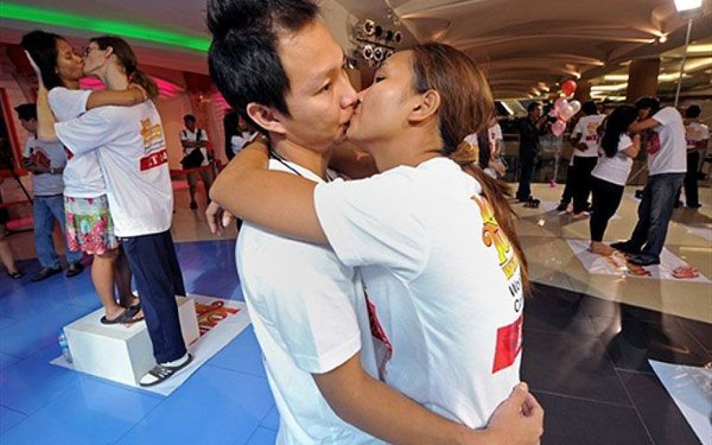 Таїланд, Паттайя. Тайські пари цілуються під час конкурсу "Найдовший безперервний поцілунок у світі", яким відзначили День Святого Валентина у місті Паттайя. Чотирнадцять пар взяли участь у "марафоні поцілунків", щоб встановити рекорд Гіннеса. / © AFP