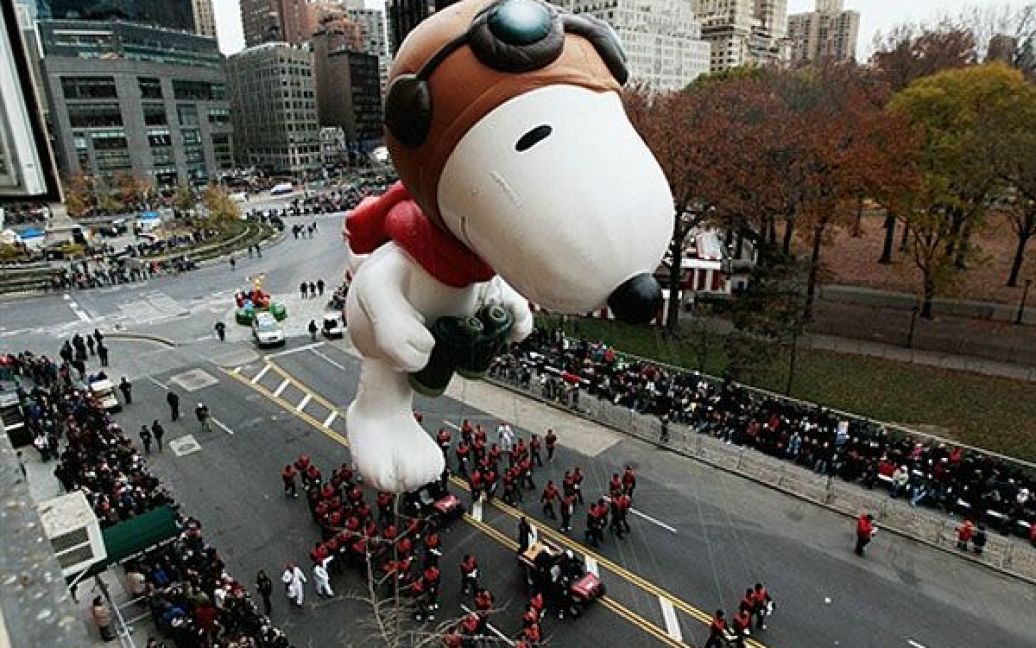 США, Нью-Йорк. Велику фігуру Снупі везуть Центральним Парком під час параду на честь святкування Дня подяки у Нью-Йорку. Цього року у яскравому параді взяли участь близько 8000 учасників і 15 гігантських повітряних куль-ляльок. / © AFP