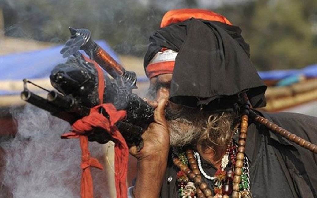 Індія, Калькутта. Індійський садху (свята людина) курить коноплю у Калькутті. Паломники індуїсти почали збиратись на свято Гангасагар Мела, яке завершиться 14 січня. / © AFP