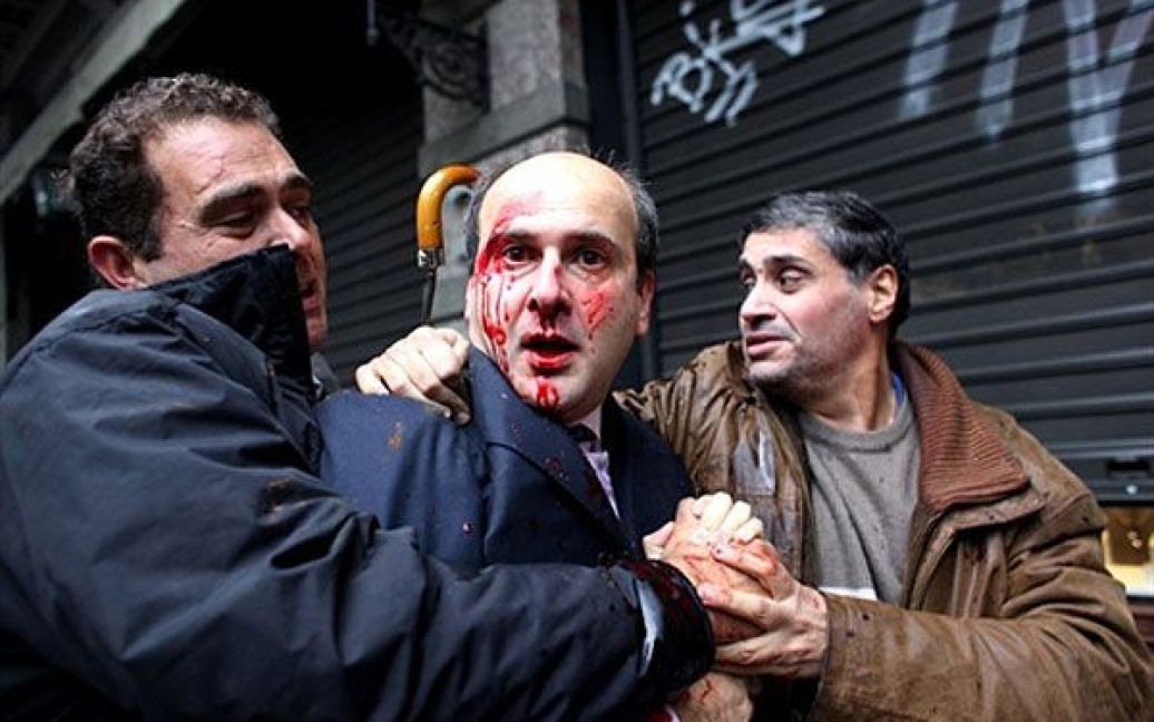 Греція, Афіни. Колишнього консервативного міністра Кіті Гатзідакіса (в центрі) побили демонстранти під час акції протесту в Афінах. / © AFP