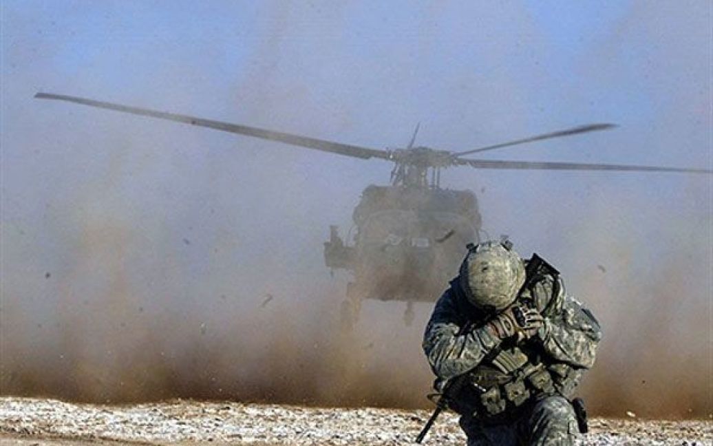 Ірак. Солдат захищає обличчя від пилу, доки злітає гелікоптер, під час спільного рейду американських і іракських сил, який провели у 100 км на південь від багатого на нафту міста Кіркук. Під час рейду військові затримали 25 розшукуваних осіб. / © AFP