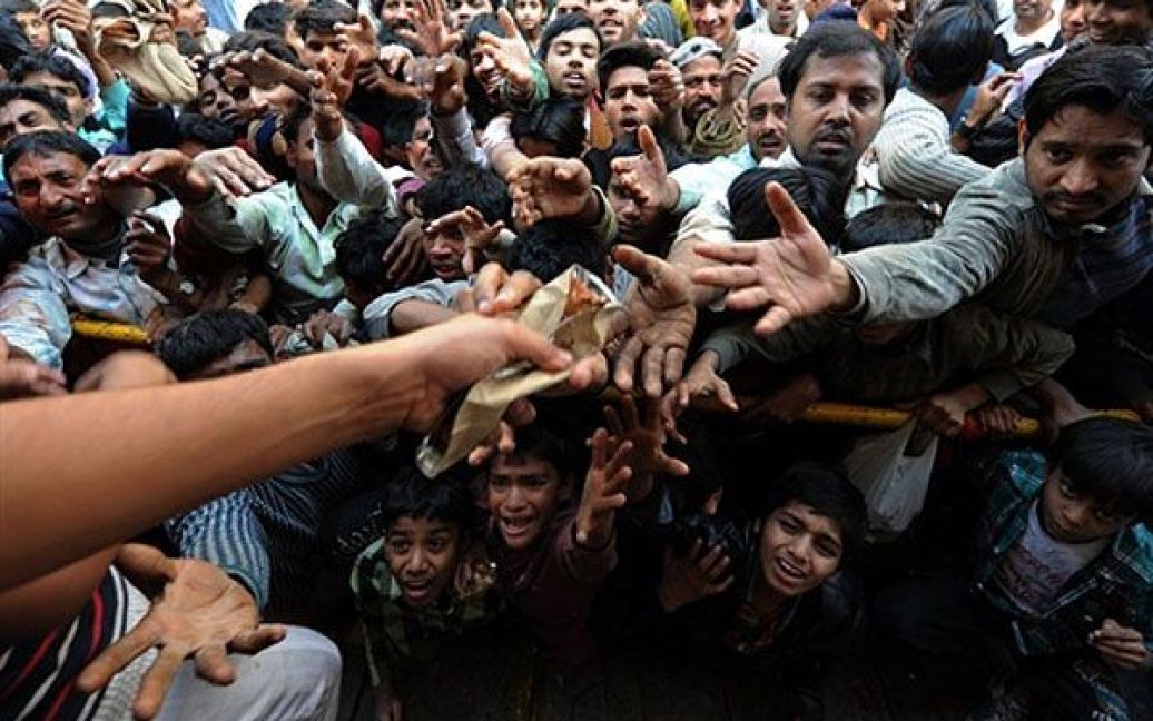 Індія, Нью Делі. Люди ведуть боротьбу за безкоштовні харчі, які роздають під час релігійної процесії у Нью-Делі. / © AFP