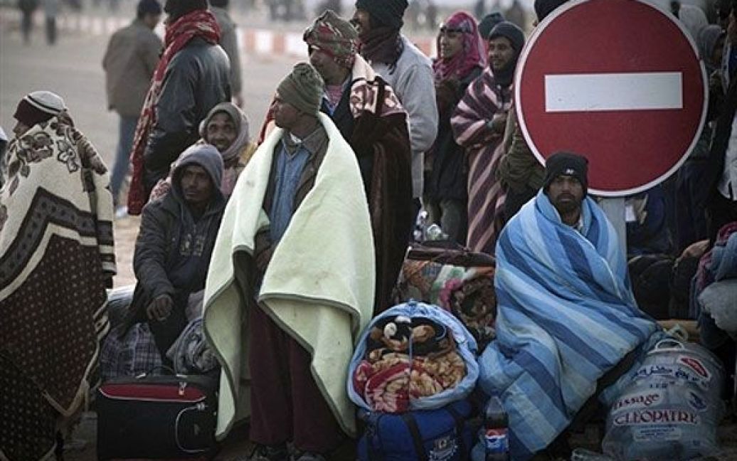 Туніс, Рас Єдір. Біженці, які втекли від бойових дій в Лівії. чекають на автобус на кордоні з Лівією після ночівлі простонеба. / © AFP
