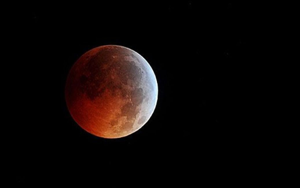 США, Манассас. Місяць під час повного місячного затемнення, яке цього року співпало з днем зимового сонцестояння. Подібне співпадіння є дуже рідкісним явищем і трапляється один раз на кілька століть. / © AFP