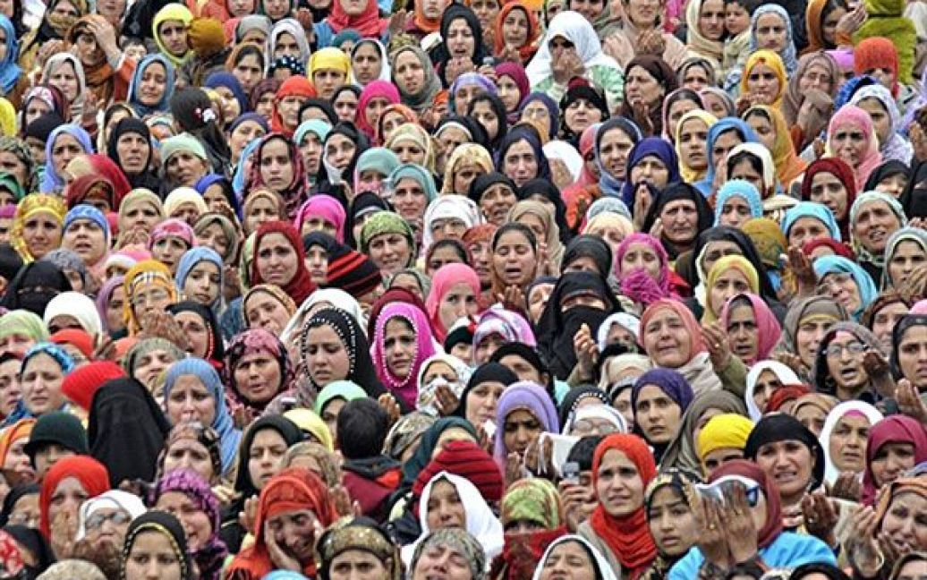 Індія, Срінагар. Кашмірські мусульмани дивляться на реліквію, яку їм показує священик, &mdash; волосся з бороди пророка Мухаммеда, у храмі Хазратбал у Срінагарі. Мусульмани відзначили свято Ід-е-Мілад-ун-Набі, день народження пророка Мухаммеда. / © AFP