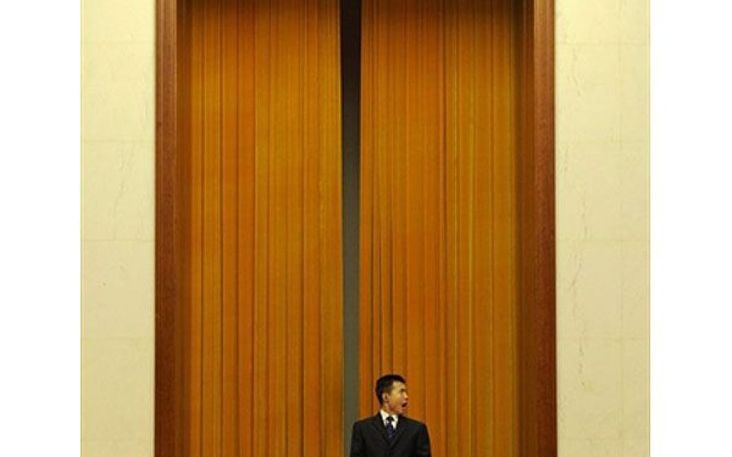 Китай, Пекін. Працівник служби безпеки позіхає, сидячи перед Великою залою народних зборів, де відбуваються Всекитайські збори народних представників. / © AFP