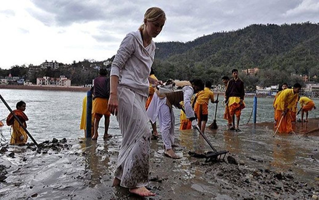 Індія, Рішікеш. Учасник Міжнародного фестивалю йоги допомагає очищати береги річки Ганг у Рішікеші. У фестивалі беруть участь представники 36 країн світу. / © AFP