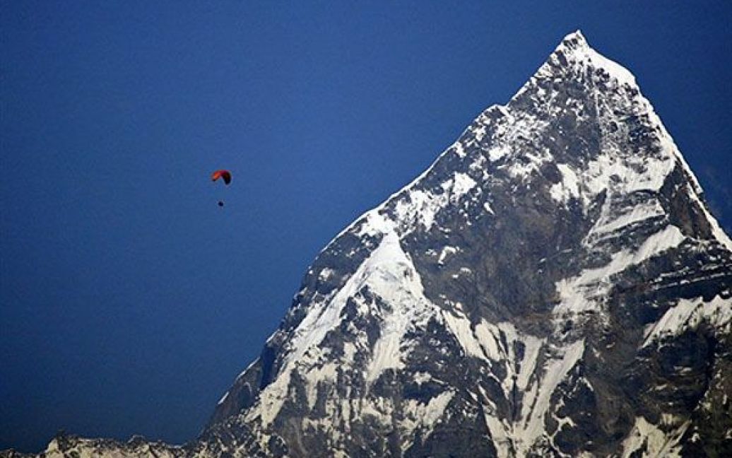 Непал, Покхара. Параплан пролітає поруч зі священною горою Мачапучаре у долині Покхара. Покхара є одним з найбільш відвідуваних туристичних місць Непалу, а гора Мачапучаре ще у 1957 році рішенням непальської влади була закрита для туристів. / © AFP