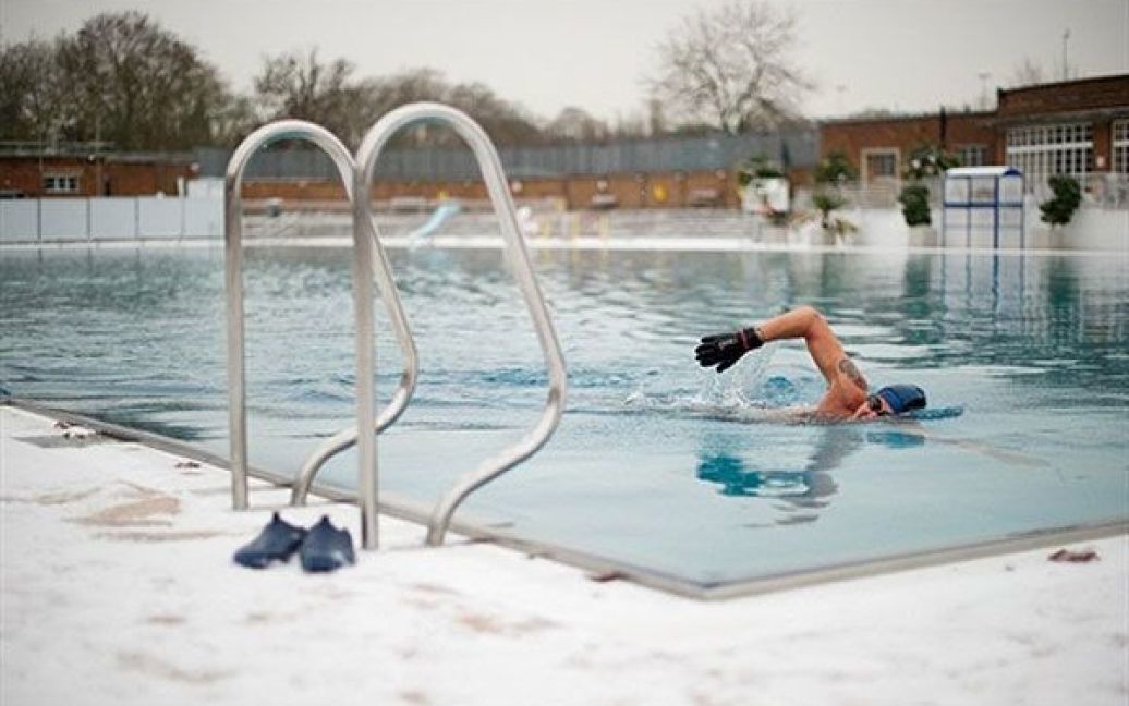 Великобританія, Лондон. Чоловік пливе у відкритому басейні в Північному Лондоні. Незважаючи на сильний сніг і низьку температуру, деякі люди не бояться крижаної води. / © AFP