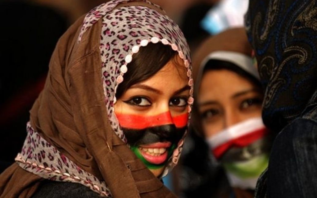 Лівійська Арабська Джамахірія, Бенгазі. Лівійські антиурядові демонстранти, обличчя яких пофарбовані у кольори національного прапора старої Лівії, беруть участь у акції в східному місті Бенгазі. Лівійські лідери протестів створили перехідну "Національну раду" і закликали Муамара Каддафі піти у відставку. / © AFP