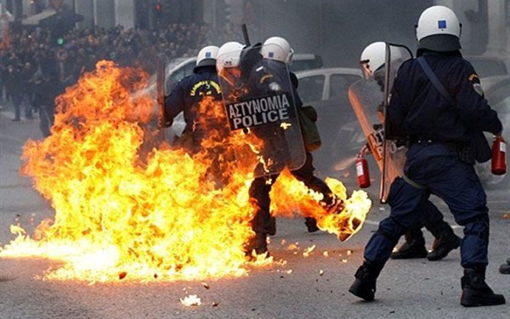 Греція, Афіни. Демонстранти кидають пляшки із запальною сумішшю у спецназівців під час акції протесту в Афінах. Поліція відкрила вогонь і по демонстрантах під час зіткнень, а протестувальники спалювали сміттєві баки та автомобілі в центрі міста. / © AFP