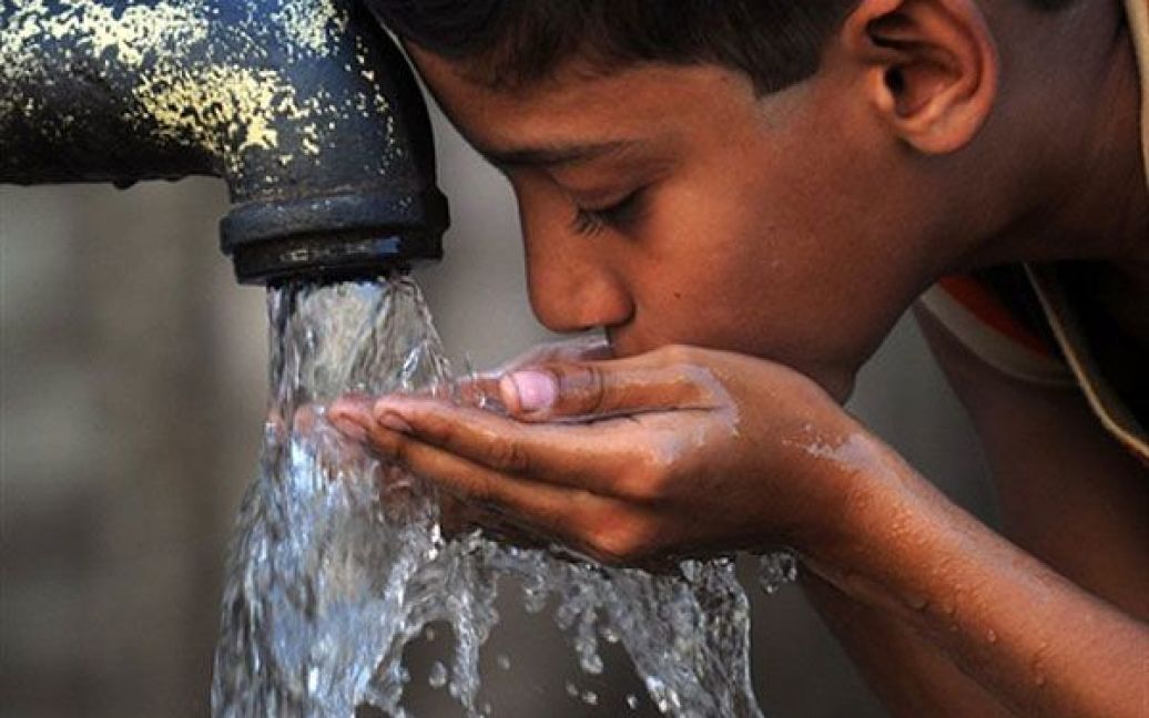 Пакистан, Карачі. Пакистанський хлопчик п&#039;є воду з ручного насоса в бідних околицях Карачі. За даними ЮНІСЕФ, більше 100 тисяч дитячих смертей у Пакистані щороку спричиняє неякісна питна вода. / © AFP