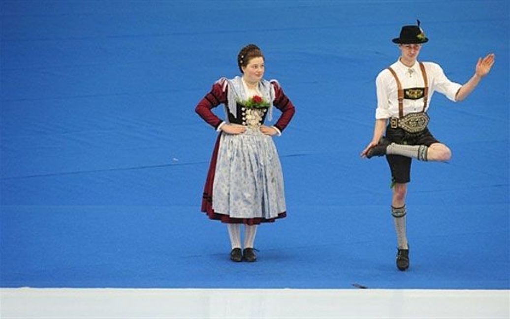 Німеччина, Інцелль. Пара, одягнена у традиційні баварські костюми, виступає на церемонії відкриття Чемпіонату світу зі швидкісних перегонів на ковзанах у південному німецькому місті Інцелль. / © AFP