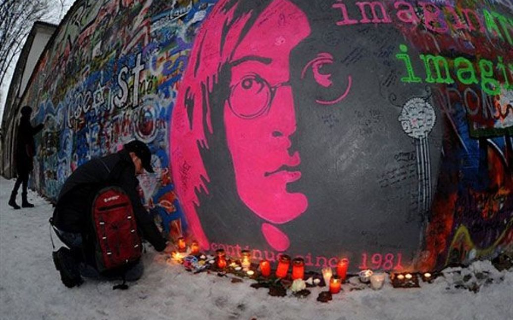 Чехія, Прага. Людина запалює свічку перед меморіальною стіною Джона Леннона в ознаменування 30-річчя з дня смерті музиканта. Леннон був убитий Марком Чепменом у Нью-Йорку 8 грудня 1980 року. / © AFP